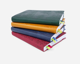 Stack of four colorful planners on a white background