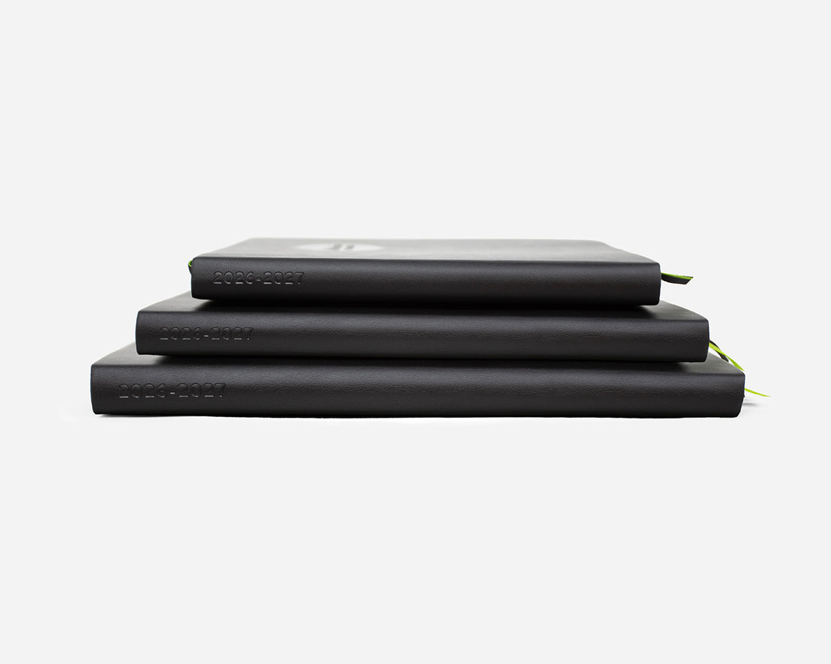 Three black planners stacked with 2026-2027 debossed on the spines on a white background
