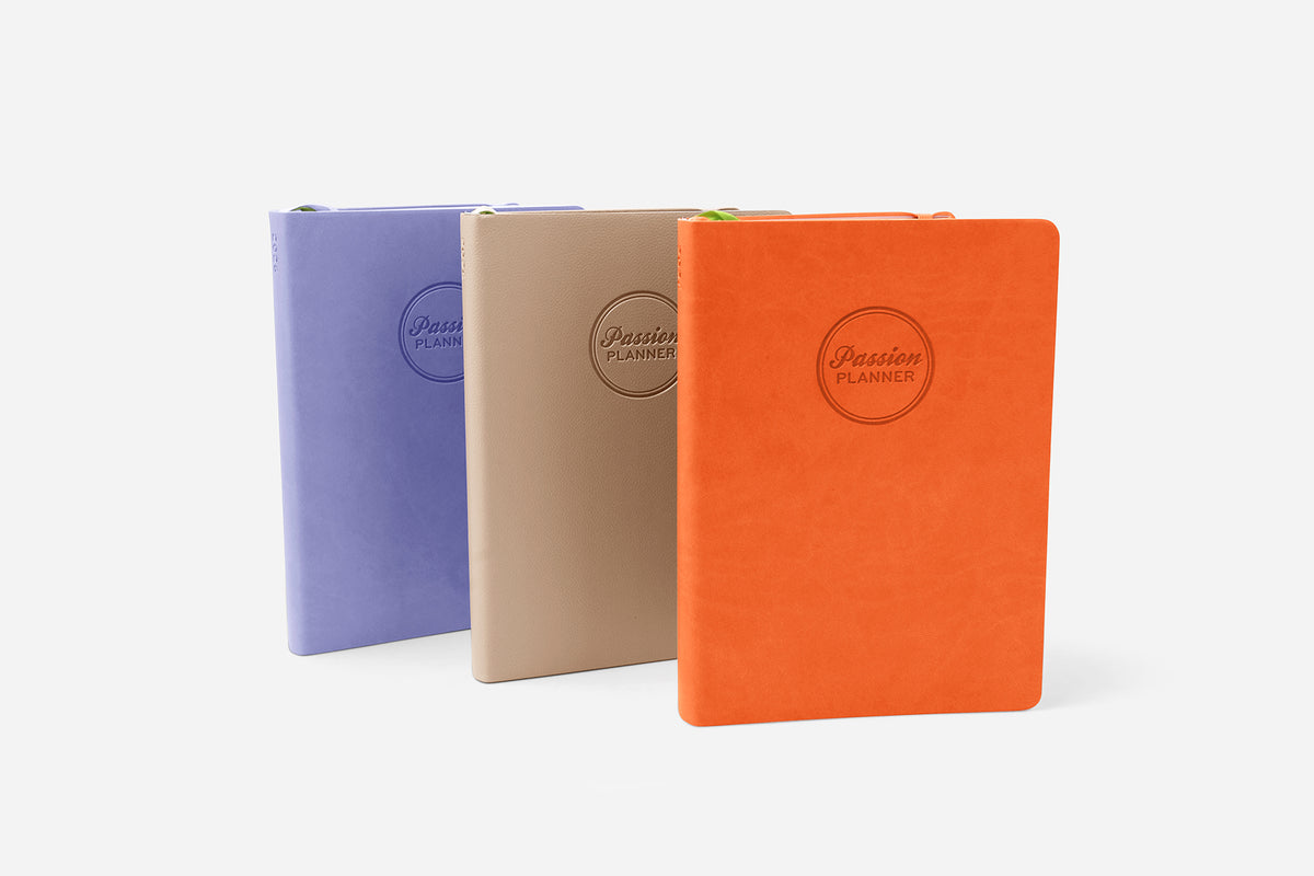 Three colorful planners with a brand logo on a white background