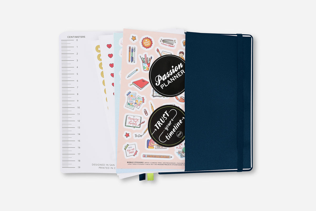 Planner with stickers and a navy cover on a white background