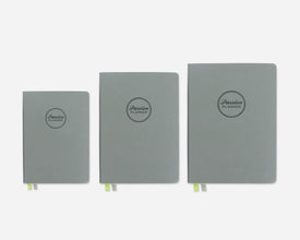 Three green planners of different sizes on a white background