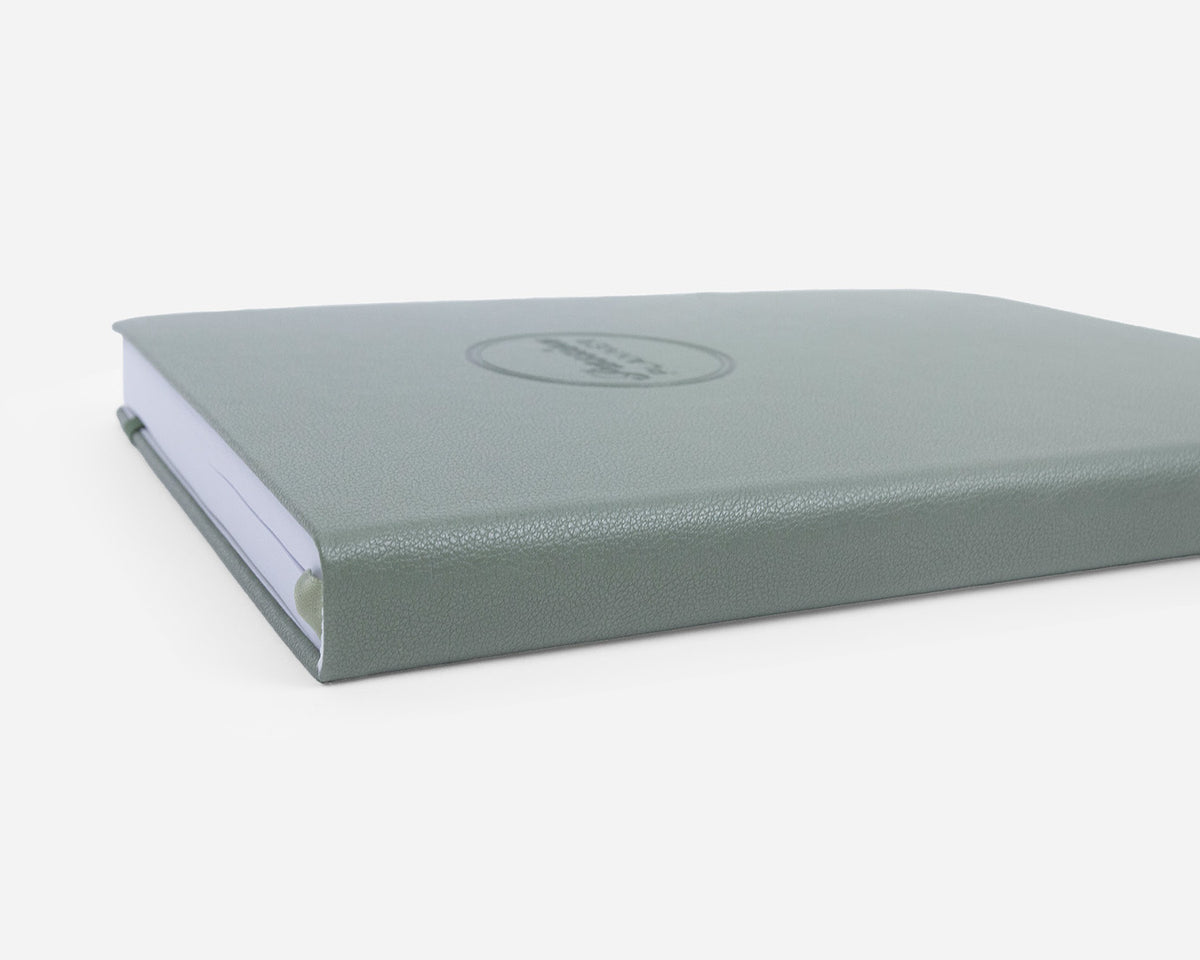 Green leather-bound planner close up on a white background