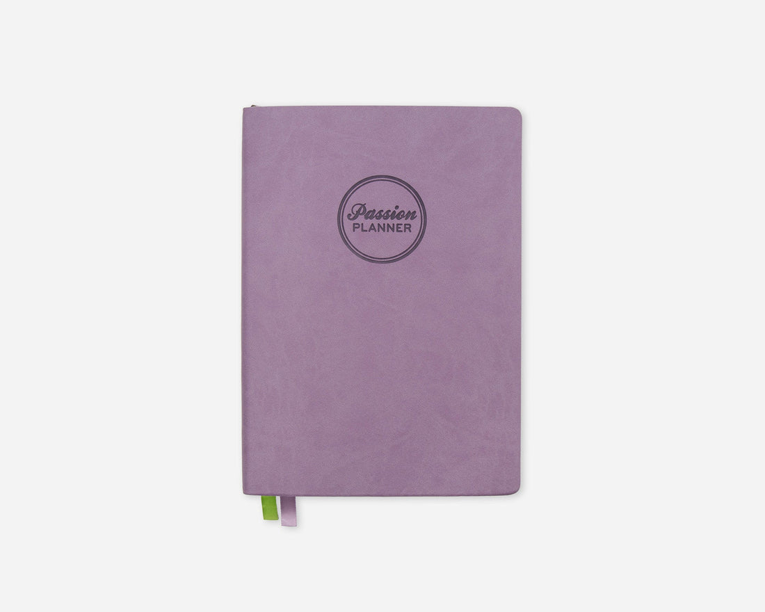 A lavender purple planner with a circular debossed logo reading &