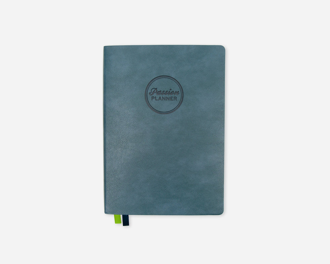 A teal blue 2027 planner with a circular debossed logo reading &