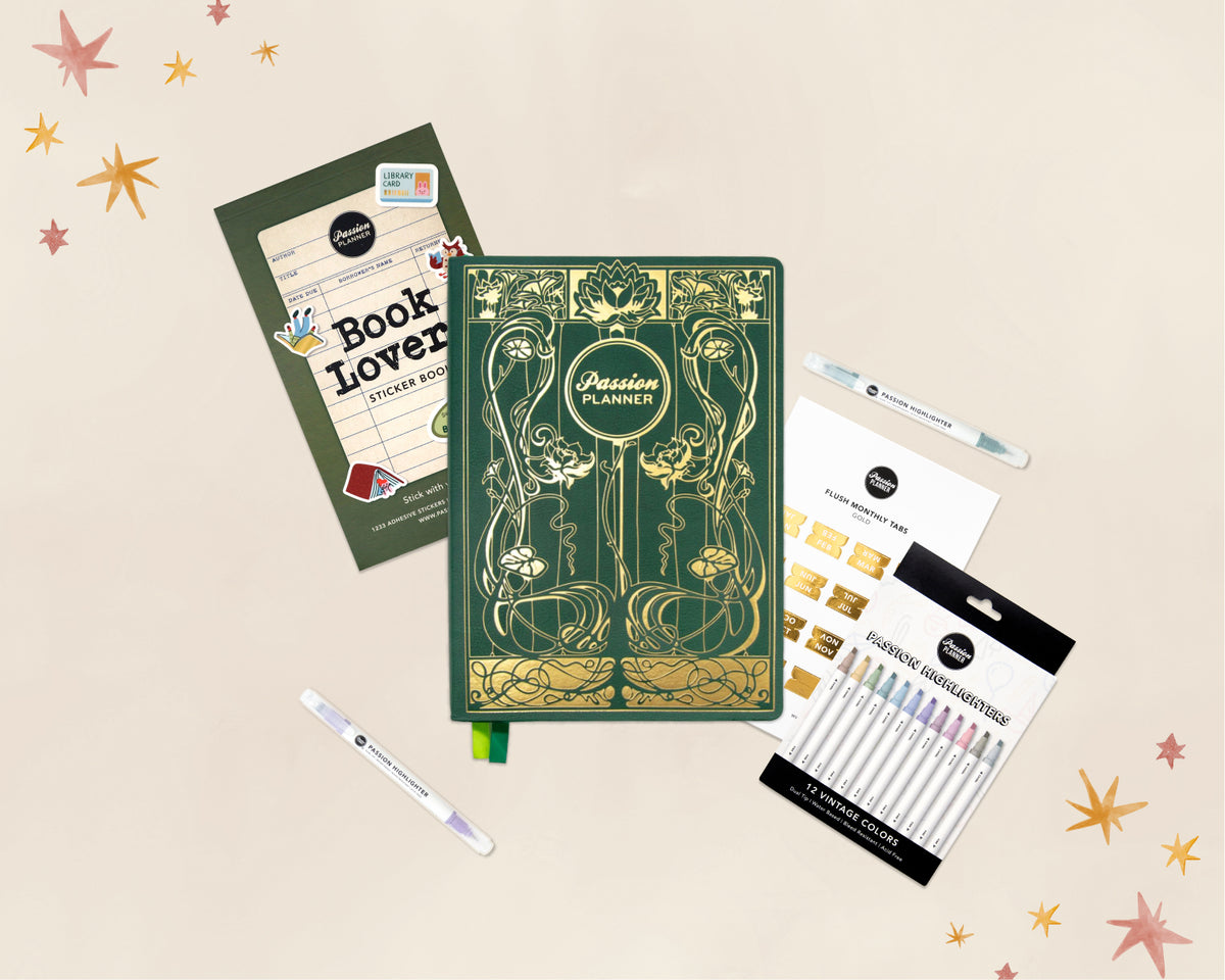 A flat-lay product arrangement on a light beige background with decorative star confetti. The main item is a green 2027 journal with ornate gold Art Nouveau-style illustrations and the title 'Passion Planner' on the cover.