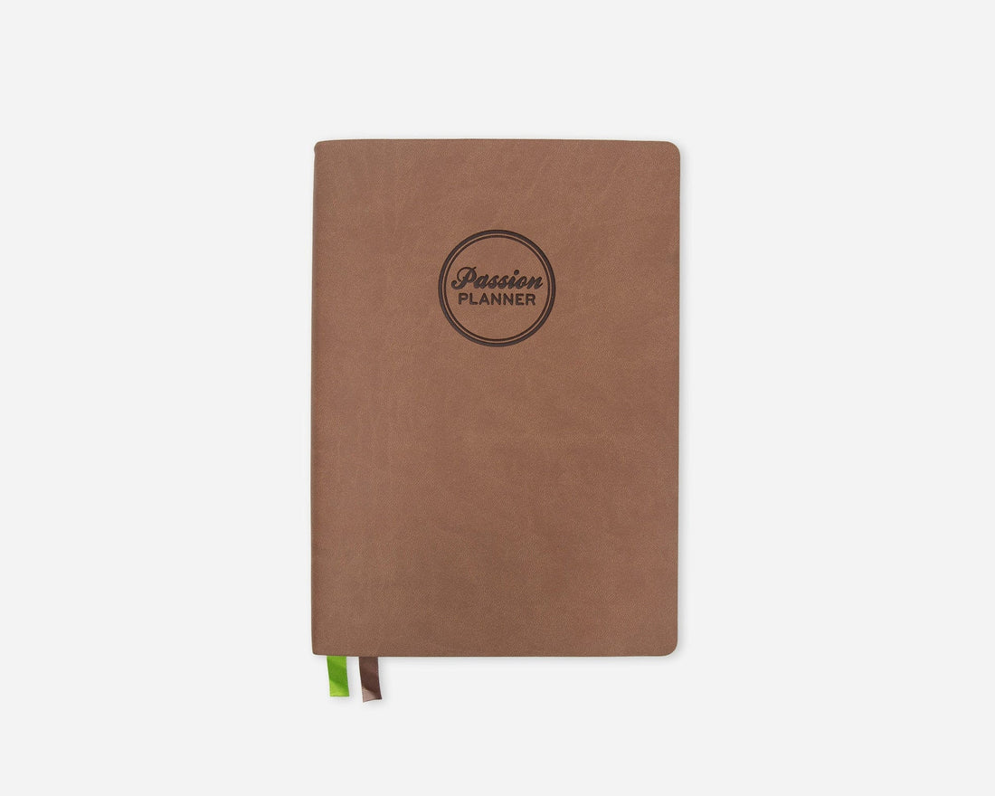A brown softcover planner with a circular black logo reading &