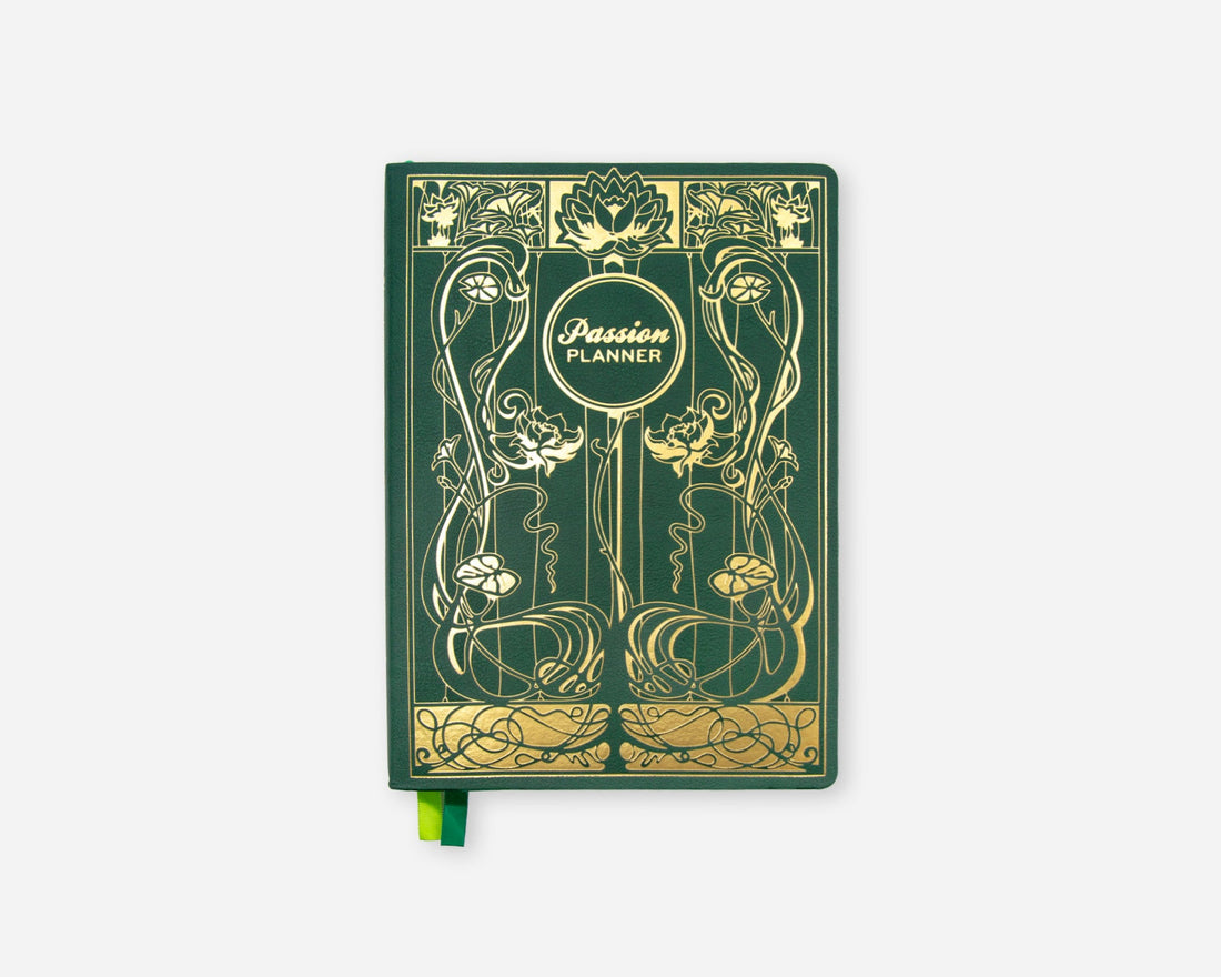 A green 2027 planner with ornate gold Art Nouveau-style illustrations and a small green ribbon bookmark, shown on a light gray background.