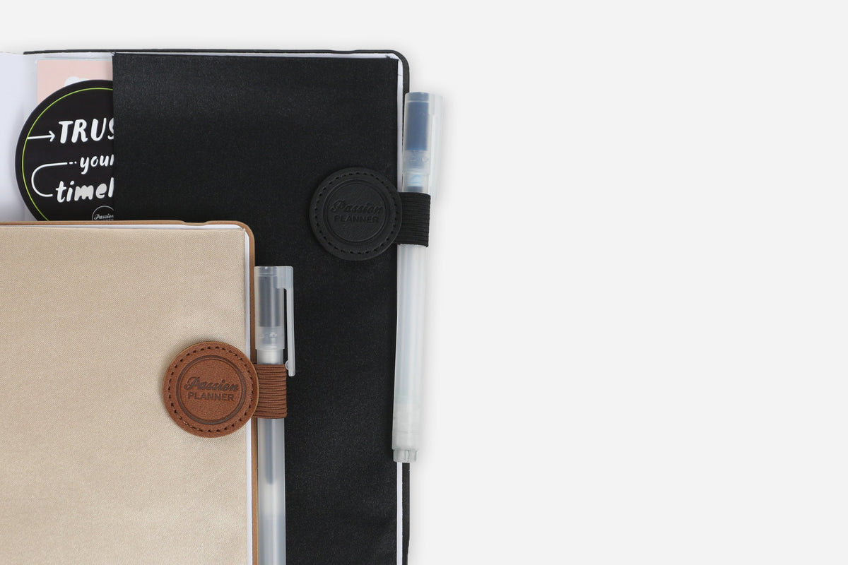 Two planners with pen holders on a white background